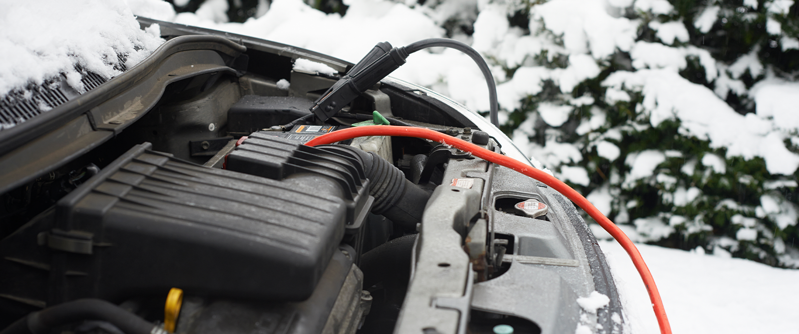a car battery hooked up to cables in the snow