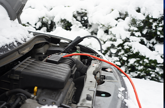 a car battery hooked up to cables in the snow
