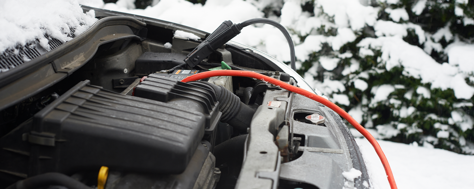 a car battery hooked up to cables in the snow