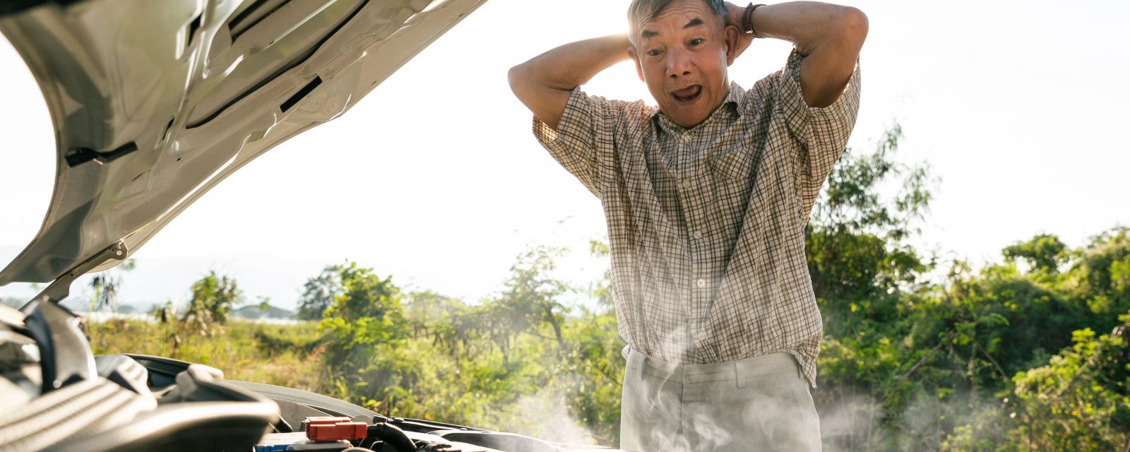 older man looking shocked at his smoking engine