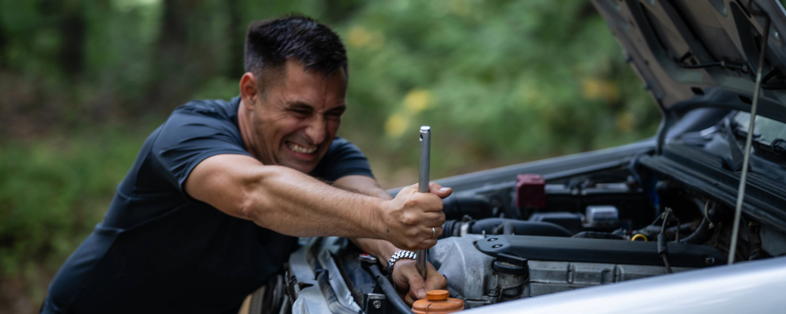 man humorously wrenching in his car