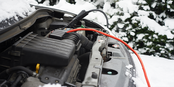 a car battery hooked up to cables in the snow