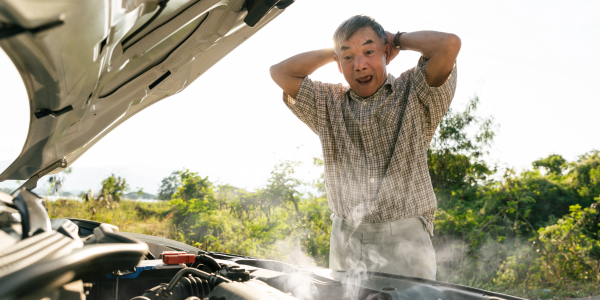 older man looking shocked at his smoking engine