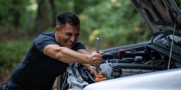 man humorously wrenching in his car