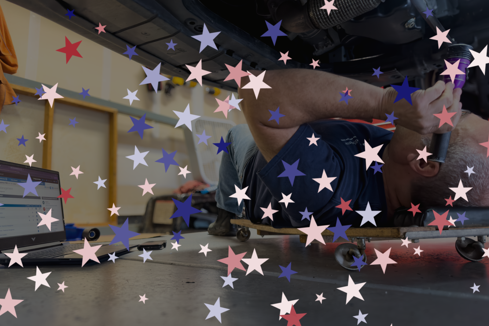 man under car with flashlight and red white and blue stars overlaying it