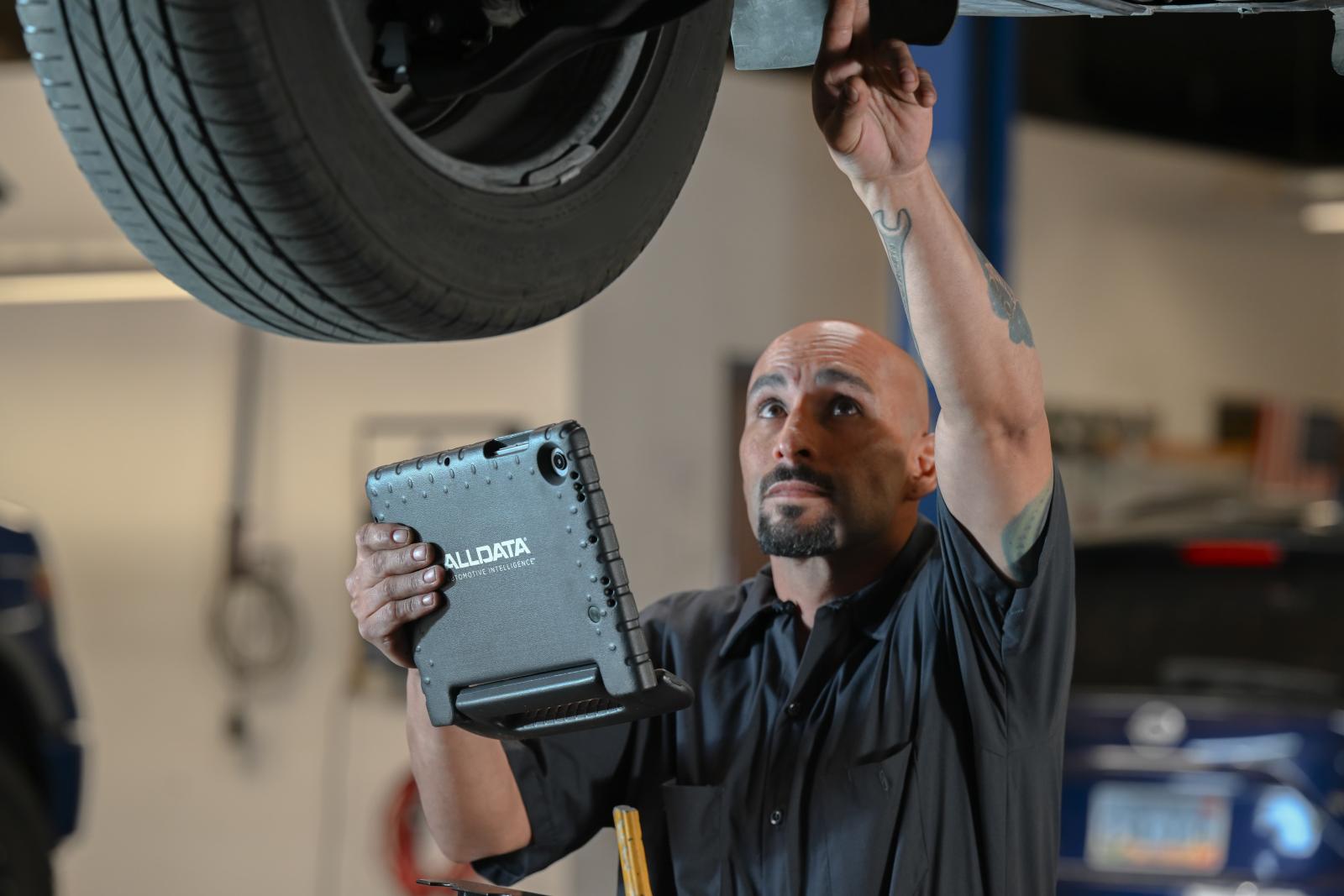 Auto Repair Shop using ALLDATA branded device to inspect the undercarriage of a vehicle