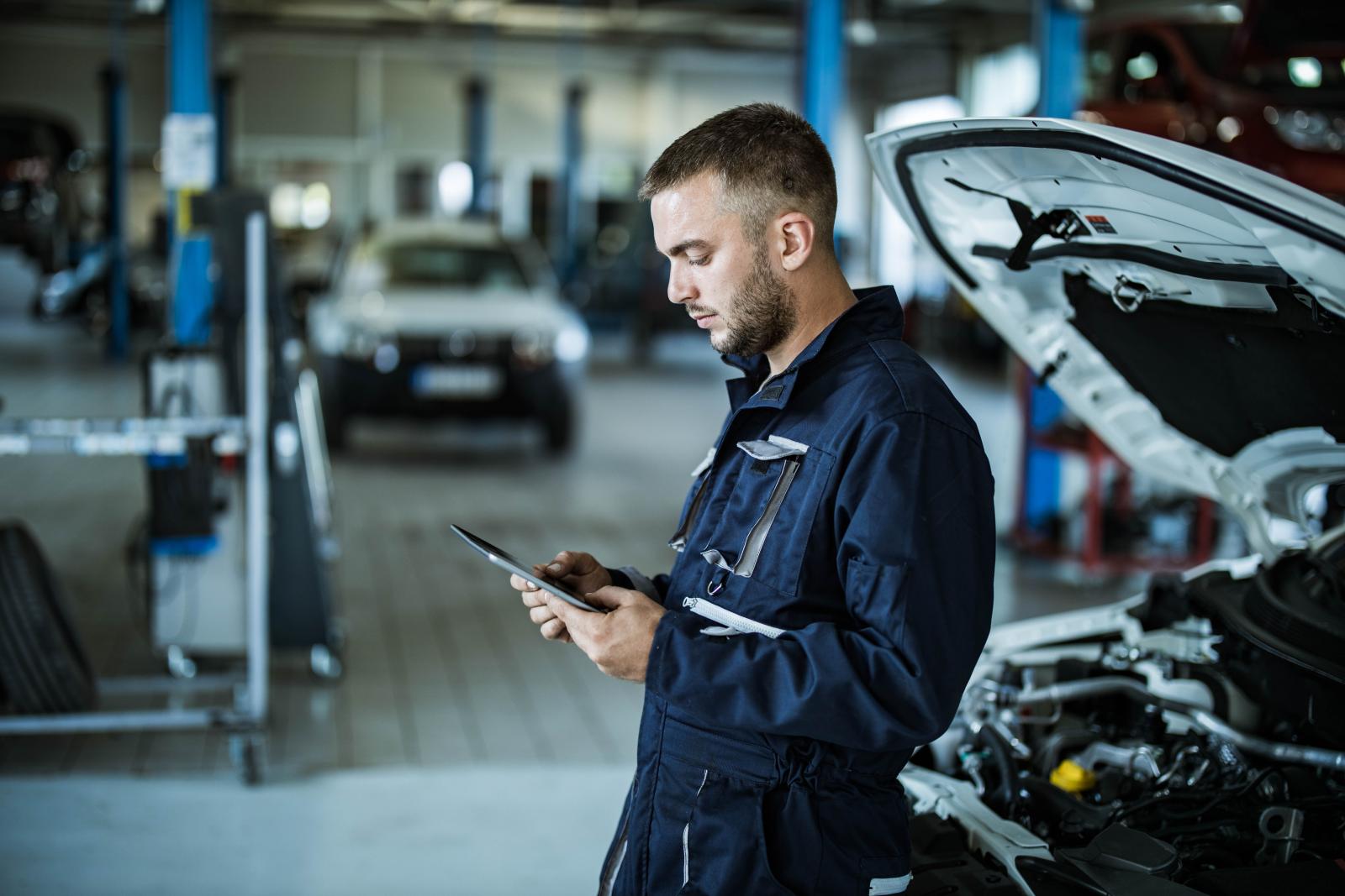 Male garage technician working on tablet 