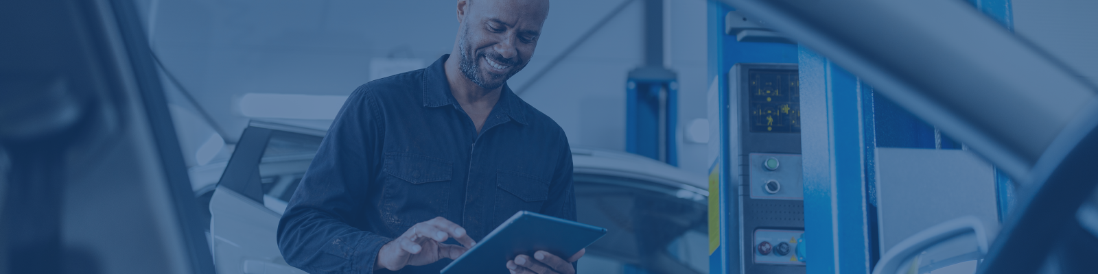 Man on tablet in front of car window
