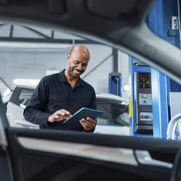 Male Technician with tablet by car window 